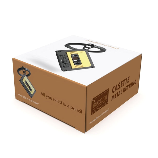 Metalinis raktų pakabukas „Audio Kasetė“ – retro kasetės 3D miniatiūra iš Muzikos Pasaulis kolekcijos. Auksinė ir juoda spalva, mini detalės, plieninis žiedas.