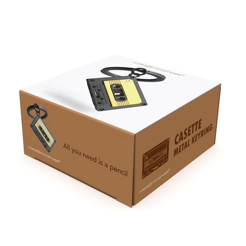 Metalinis raktų pakabukas „Audio Kasetė“ – retro kasetės 3D miniatiūra iš Muzikos Pasaulis kolekcijos. Auksinė ir juoda spalva, mini detalės, plieninis žiedas.