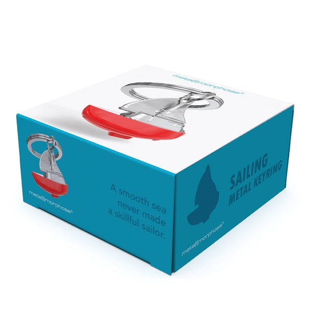 Metalmorphose.lt metalinis raktų pakabukas BURLAIVIS. Baltas su raudonu burlaivio korpusas ir pakeltos burės. Premium cinko lydinys, nerūdijančio plieno žiedas. 3D pakabukas iš KELIONIŲ PASAULIS kolekcijos.