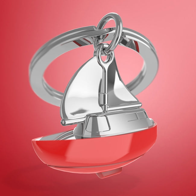 Metalmorphose.lt metalinis raktų pakabukas BURLAIVIS. Baltas su raudonu burlaivio korpusas ir pakeltos burės. Premium cinko lydinys, nerūdijančio plieno žiedas. 3D pakabukas iš KELIONIŲ PASAULIS kolekcijos.