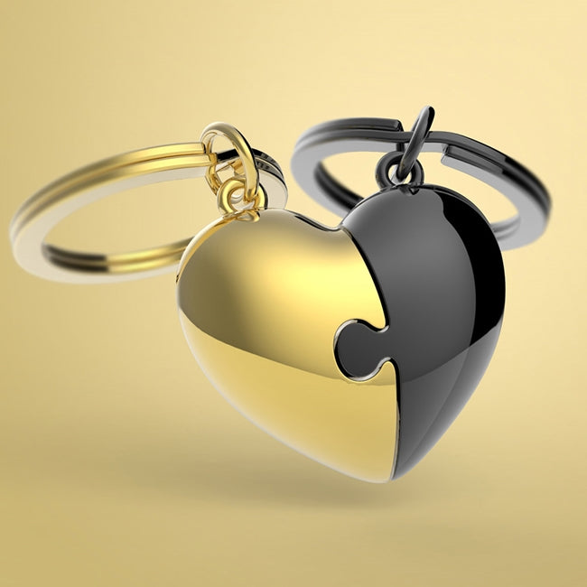 Metalmorphose.lt metalinis raktų pakabukas DVI ŠIRDYS. Auksinė ir juoda širdelės, sujungtos kaip romantiška dėlionė. Premium metalas. MEILĖS PASAULIS kolekcija.
