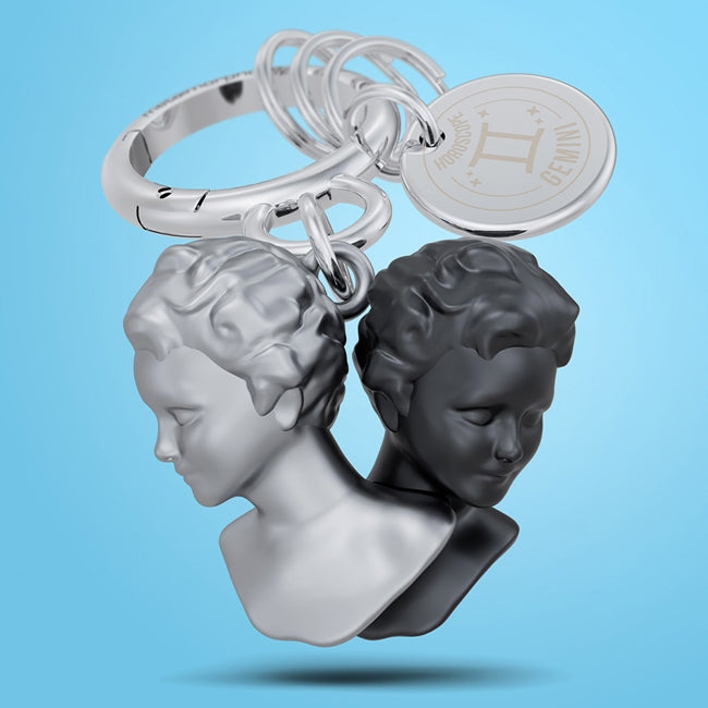 Metalmorphose.lt metalinis raktų pakabukas DVYNIAI. Du juodas ir baltas, stilizuoti veidai, oro ženklo simbolika, premium metalo miniatiūra, nerūdijančio plieno žiedas. Pakabukas iš ZODIAKŲ PASAULIS kolekcijos.