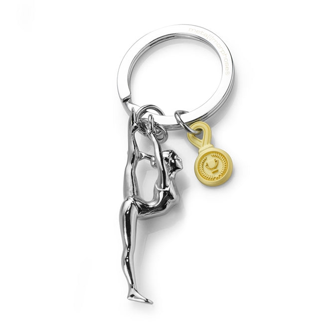 Metalmorphose.lt metalinis raktų pakabukas GIMNASTIKOS MŪZA. 3D gimnastės figūra su auksiniu #1 medaliu, detalus cinko lydinio dizainas, plieno žiedas. SPORTO PASAULIS kolekcija.