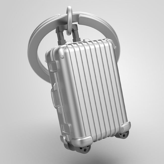 Metalmorphose.lt metalinis raktų pakabukas LAGAMINAS. Metalinis bagažo korpusas, vertikalios linijos, mini ratukai, 3D lagamino miniatiūra. Nerūdijančio plieno žiedas. Pakabukas iš KELIONIŲ PASAULIS kolekcijos.