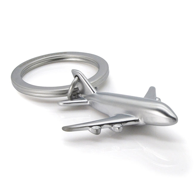 Metalmorphose.lt metalinis raktų pakabukas LĖKTUVAS. Sidabrinis metalinis lėktuvo korpusas, detalūs sparnai, realistiška 3D lėktuvo miniatiūra, skrydžio simbolis. Nerūdijančio plieno žiedas. Pakabukas iš KELIONIŲ PASAULIS kolekcijos.