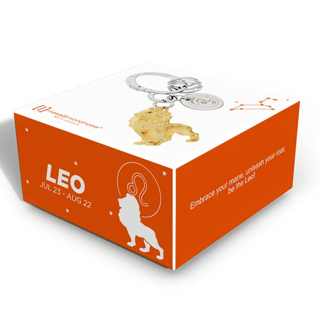 Metalmorphose.lt metalinis raktų pakabukas LIŪTAS. Karališka auksinio liūto galva su detaliais karčiais, saulės ženklo simbolika, premium cinko lydinys ir plieno žiedas. Pakabukas iš ZODIAKŲ PASAULIS kolekcijos.