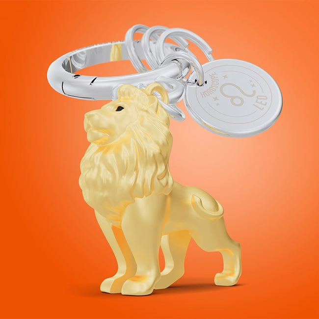 Metalmorphose.lt metalinis raktų pakabukas LIŪTAS. Karališka auksinio liūto galva su detaliais karčiais, saulės ženklo simbolika, premium cinko lydinys ir plieno žiedas. Pakabukas iš ZODIAKŲ PASAULIS kolekcijos.