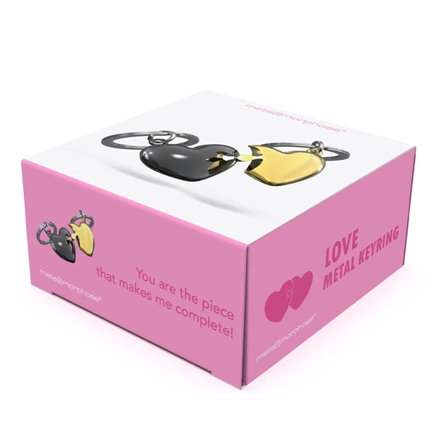 Metalmorphose.lt metalinis raktų pakabukas MEILĖS DĖLIONĖ. Juoda ir auksinė širdys sujungtos kaip dėlionės dalys. Premium metalas. MEILĖS PASAULIS kolekcija.
