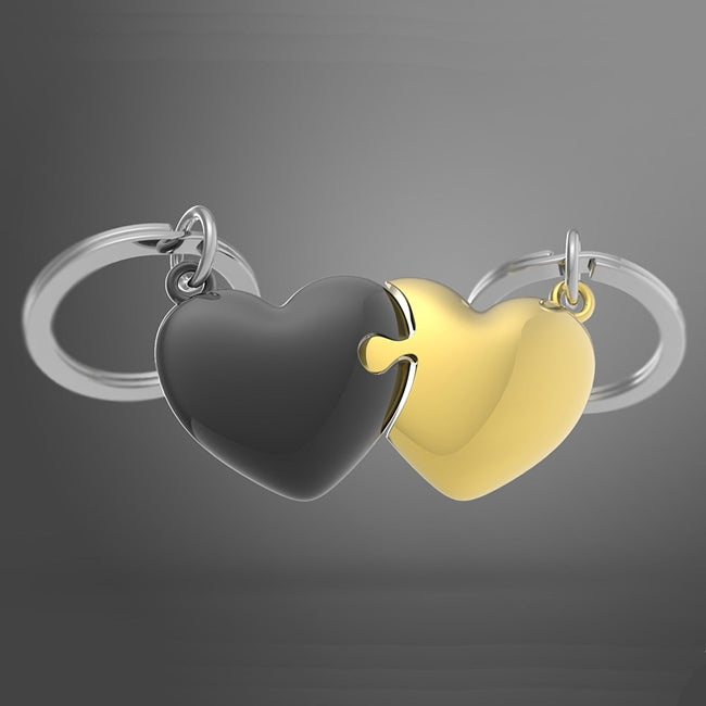 Metalmorphose.lt metalinis raktų pakabukas MEILĖS DĖLIONĖ. Juoda ir auksinė širdys sujungtos kaip dėlionės dalys. Premium metalas. MEILĖS PASAULIS kolekcija.