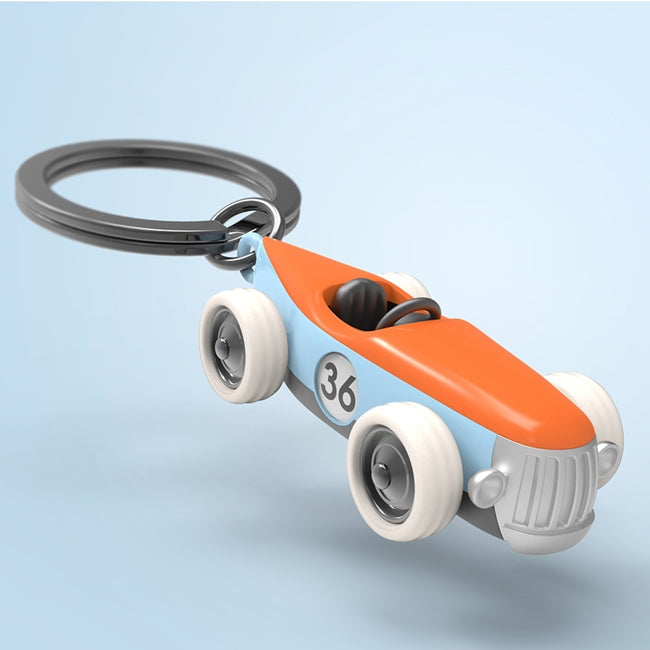 Metalmorphose.lt metalinis raktų pakabukas NOELIO BOLIDAS. Premium cinko lydinio vintage lenktyninio automobilio 3D miniatiūra, oranžinės ir dangaus mėlynumo detalės, silikoniniai judantys ratukai, nerūdijančio plieno žiedas. Raktų pakabukas iš TRANSPORTO PASAULIS kolekcijos.