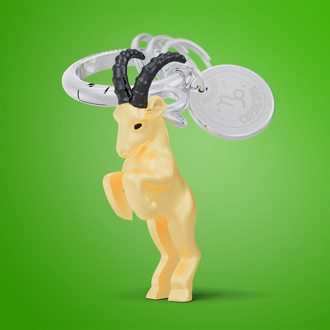 Metalmorphose.lt metalinis raktų pakabukas OŽIARAGIS. Auksinė 3D Ožiaragio ženklo miniatiūra, žemės elemento simbolika, premium cinko lydinys, plieno žiedas. Pakabukas iš ZODIAKŲ PASAULIS kolekcijos.