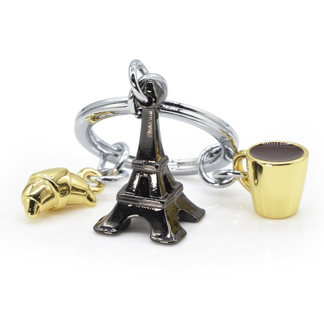 Metalmorphose.lt metalinis raktų pakabukas PARYŽIAUS TRIO. Juodas Eifelio bokštas, auksinis kruasanas ir auksinis kavos puodelis. 3D prancūziškų miniatiūrų rinkinys. Nerūdijančio plieno žiedas. Pakabukas iš KELIONIŲ PASAULIS kolekcijos.
