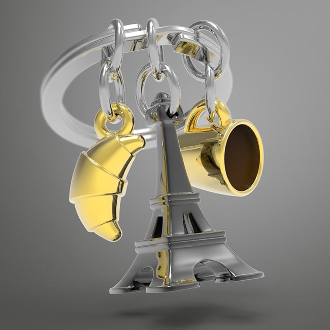 Metalmorphose.lt metalinis raktų pakabukas PARYŽIAUS TRIO. Juodas Eifelio bokštas, auksinis kruasanas ir auksinis kavos puodelis. 3D prancūziškų miniatiūrų rinkinys. Nerūdijančio plieno žiedas. Pakabukas iš KELIONIŲ PASAULIS kolekcijos.
