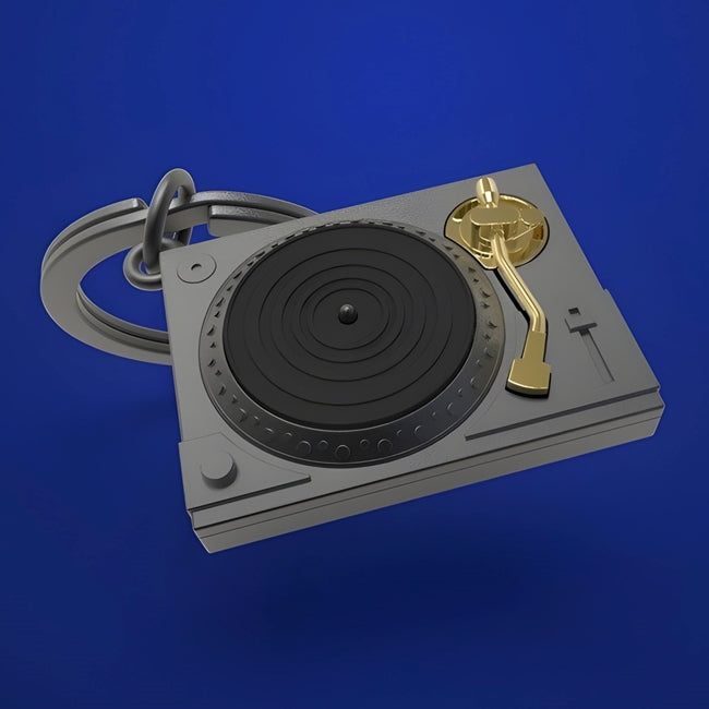 Metalinis raktų pakabukas „Patefono Laikas“ – patefono ir vinilo 3D dizainas iš Metalmorphose Muzikos Pasaulis kolekcijos. Auksinė adata, juodas vinilas, plieninis žiedas.