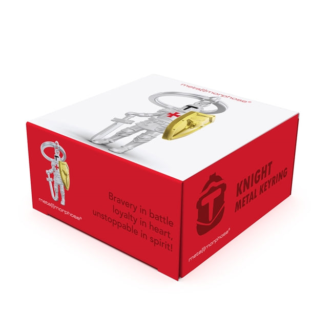 Metalmorphose.lt metalinis raktų pakabukas RITERIS. Tvirtas metalinis korpusas, auksiniai akcentai, nudažytas raudonas kryžius, riterio su kardu ir skydu 3D miniatiūra. Nerūdijančio plieno žiedas. Pakabukas iš KASDIENYBĖS PASAULIS kolekcijos.