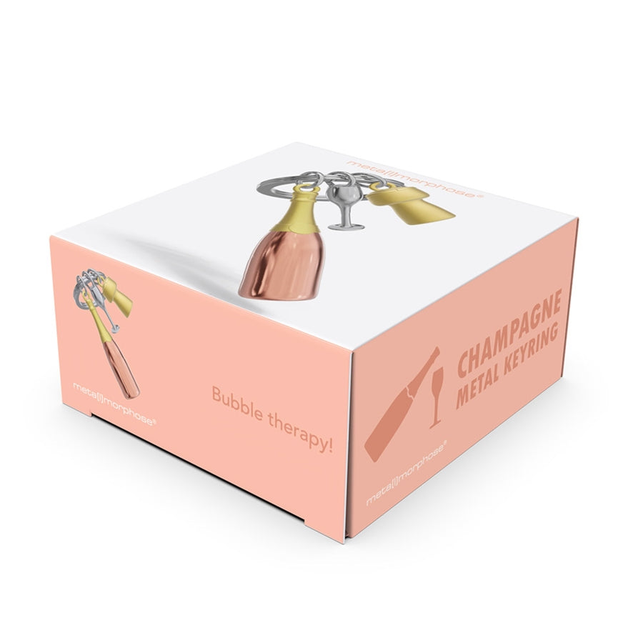 Metalmorphose metalinis raktų pakabukas „Rožinė Šampano Akimirka“ – rožinio šampano 3D butelis su taure ir kamščiu iš Skonių Pasaulis kolekcijos.