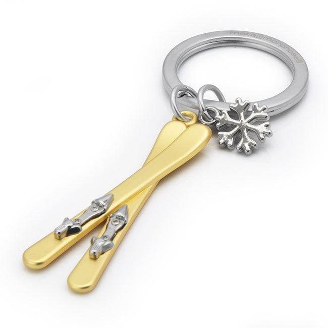 Metalmorphose.lt metalinis raktų pakabukas SLIDĖS IR SNAIGĖ. AUKSINĖS 3D slidės su metaliniais segtuvais, šalia blizgi metalinė snaigė, premium cinko lydinys, plieno žiedas. SPORTO PASAULIS kolekcija.