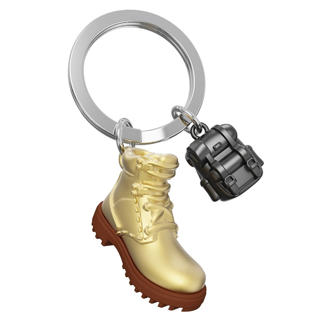 Metalmorphose.lt metalinis raktų pakabukas ŽYGEIVIO ŽINGSNIAI. Auksinis žygio batas ir juoda kuprinė, 3D hiking miniatiūra. Premium cinko lydinys, nerūdijančio plieno žiedas. Pakabukas iš KELIONIŲ PASAULIS kolekcijos.
